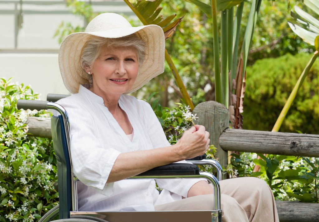 Mature woman in her wheelchair in the garden
